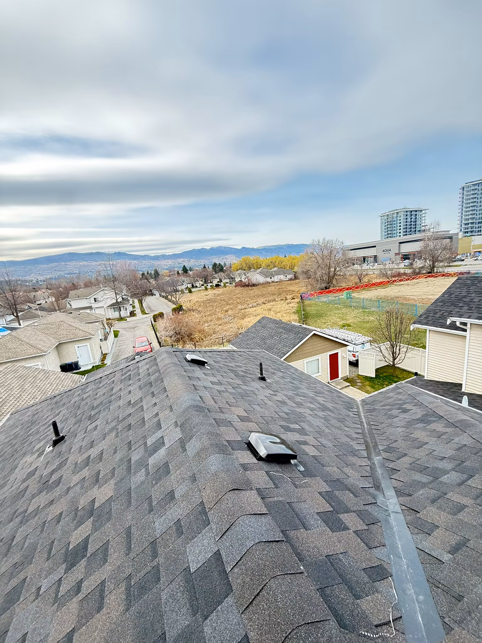 Quality asphalt shingle roofing with clean ridge lines on residential home — West Kelowna