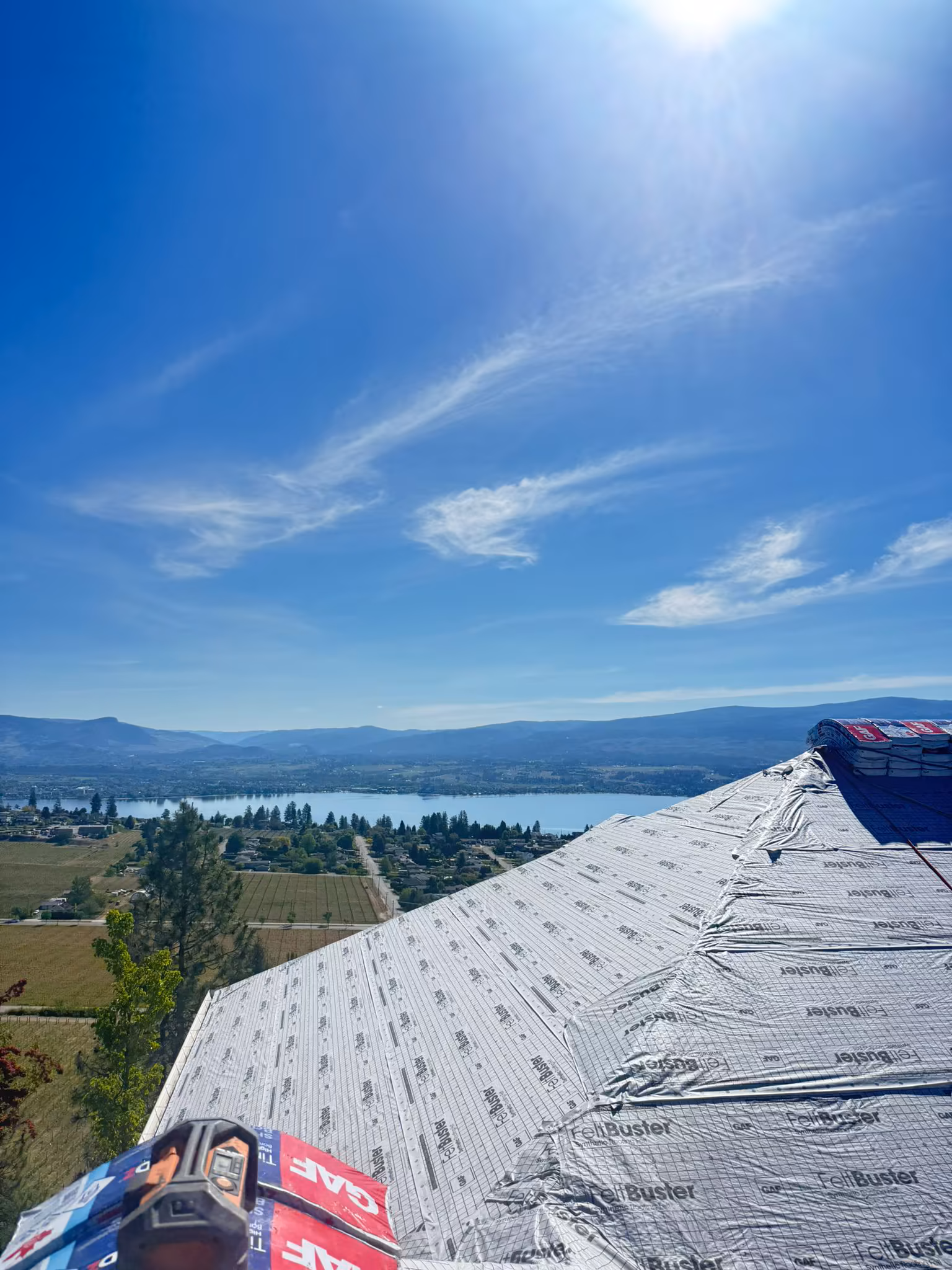 Finished dark tone architectural shingle roof on two-story Okanagan home — West Kelowna