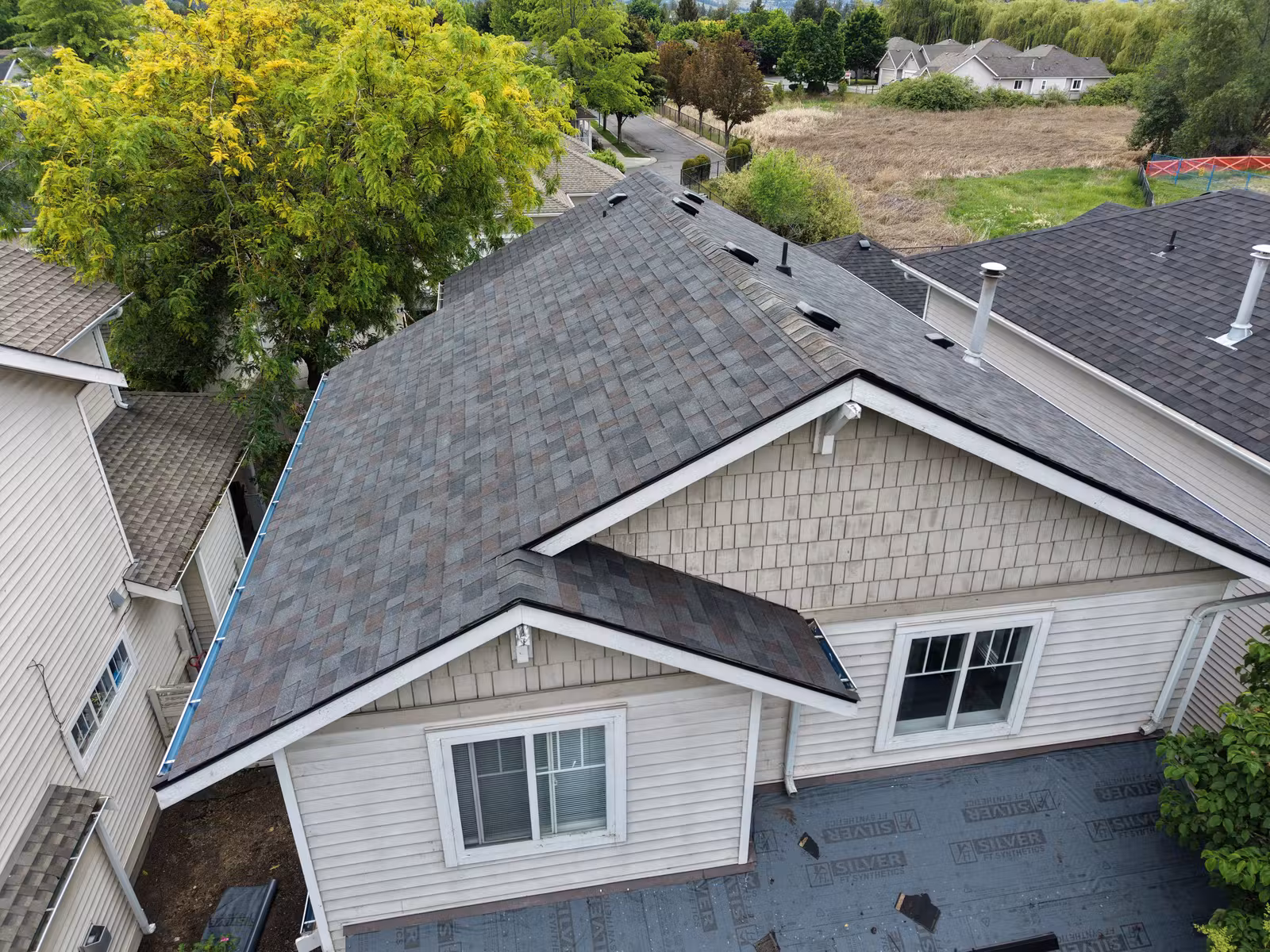 Close aerial view of a multi-unit asphalt shingle roof in Kelowna's Lower Mission